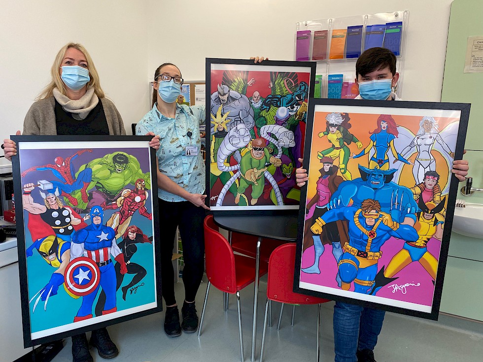 Josh Agozzino hands over three poster illustrations to the members of the Royal Alexandra Children's Hospital in Brighton