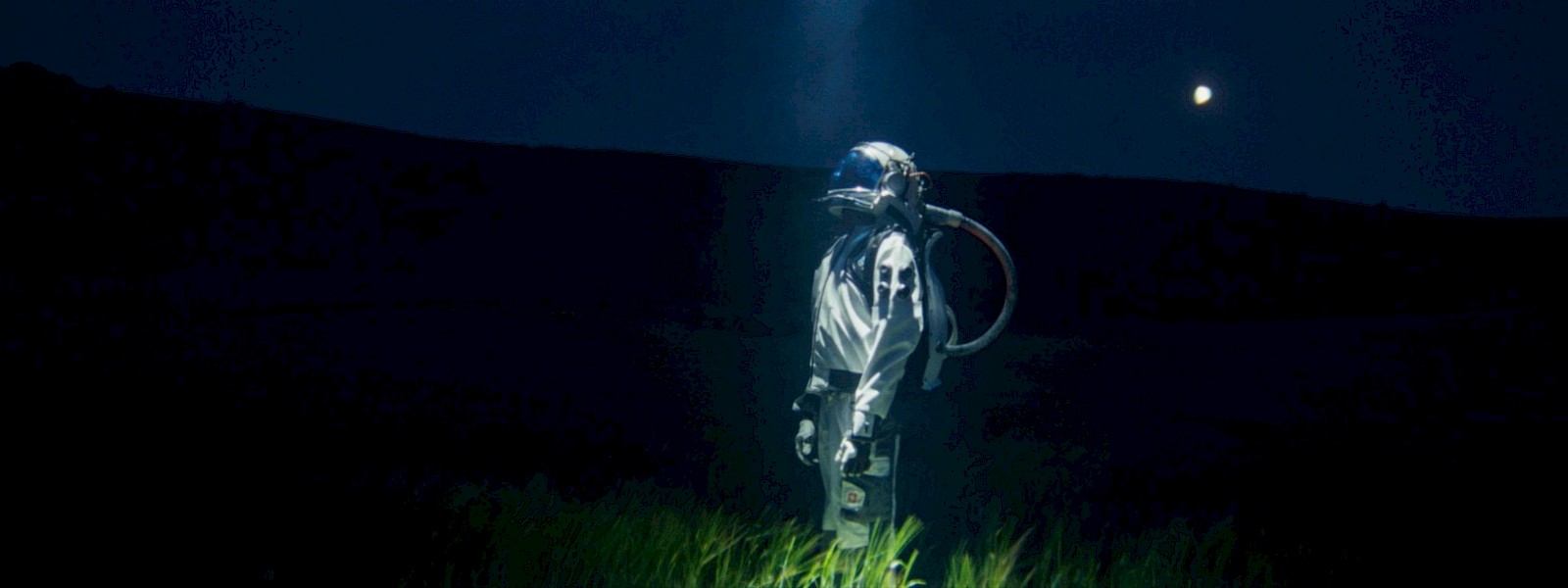 The astronaut character illuminated in the field during filming